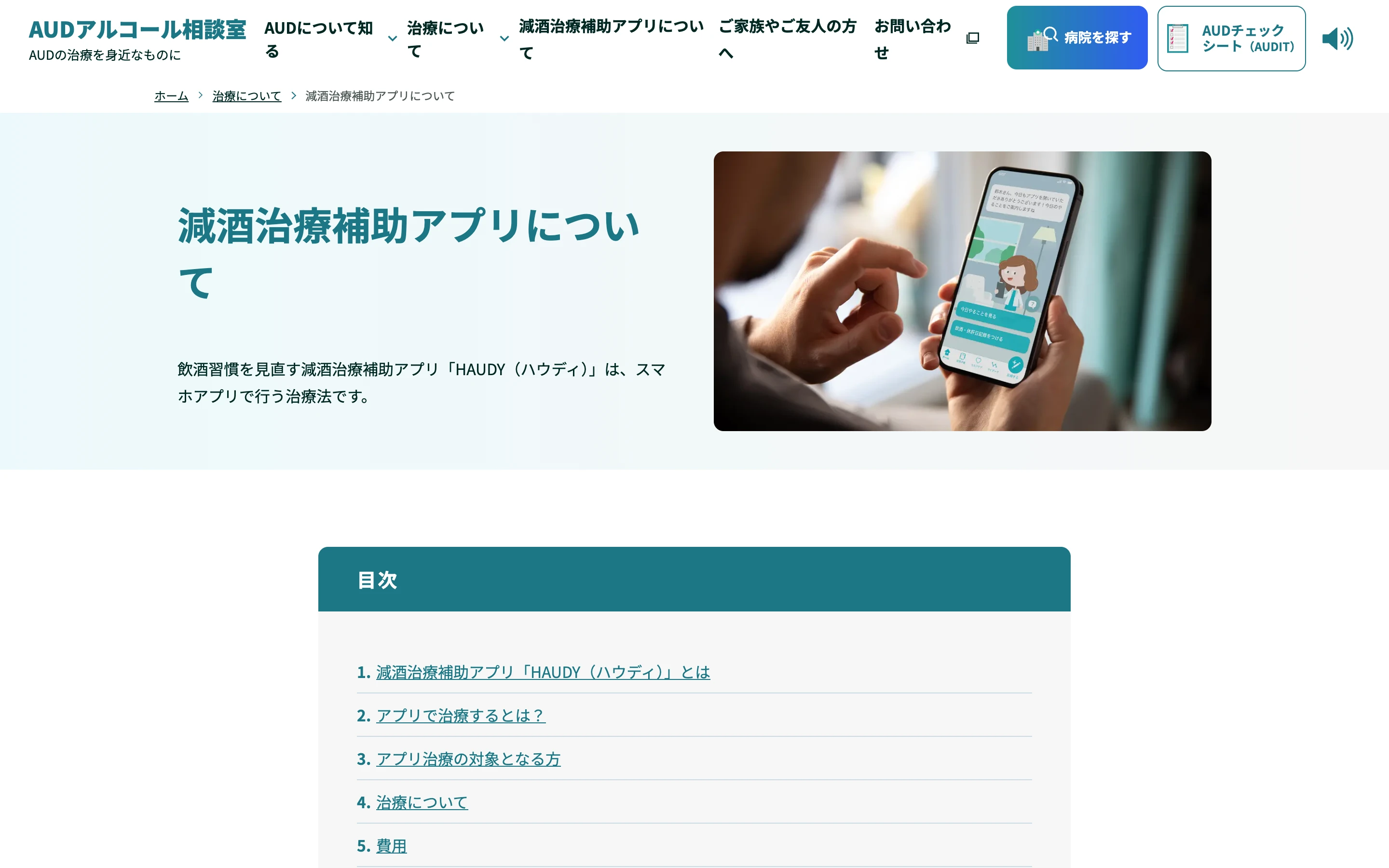 AUD アルコール相談室の「減酒治療補助アプリについて」ページ。見出しと、スマートフォンでキャラクターが案内するアプリ画面を操作する手元の写真、目次が写っている